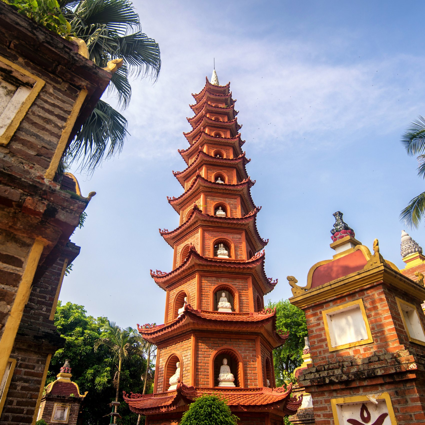 Detailaufnahme der Tran-Quoc-Pagode mit roten Ziegeln und Buddhastatuen