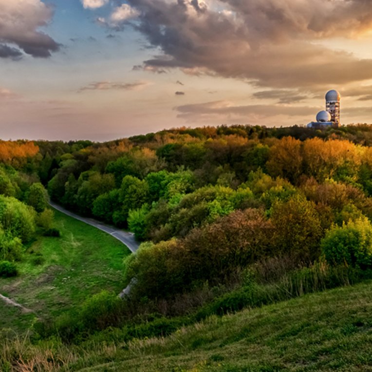 Coucher de soleil sur l'observatoire à Berlin, avec des couleurs chaudes illuminant le ciel.