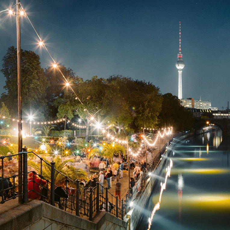 Une rivière à Berlin avec un pont illuminé, créant une ambiance nocturne magique.