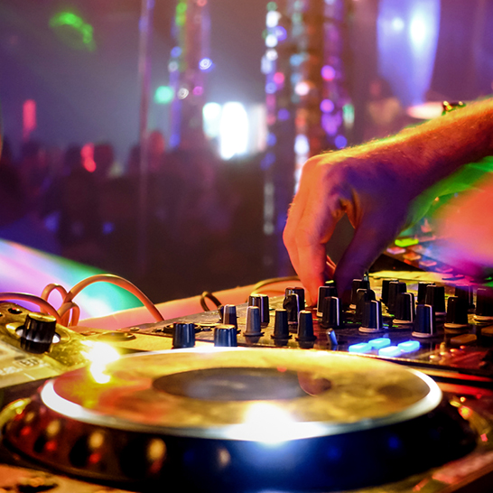 Un DJ mixe de la musique lors d'une fête à Berlin, créant une ambiance festive et entraînante.