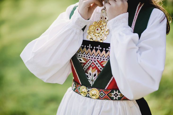 Eine Frau in traditioneller Kleidung posiert für ein Foto, um die norwegische Kultur zu zeigen.