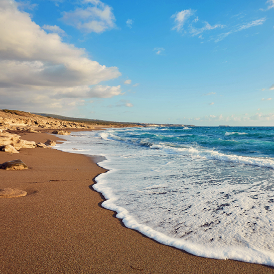 Belle plage de sable dorée et de vagues à Paphos, Chypre.