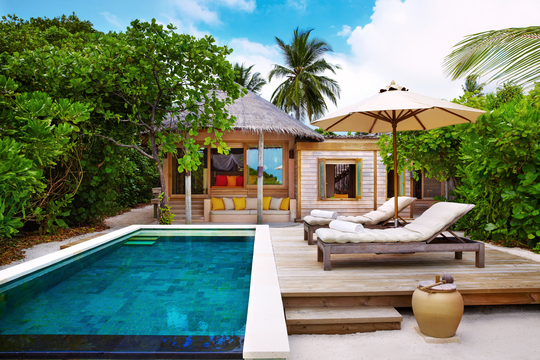 Familien Beach Villa mit Pool umgeben von Sträuchern